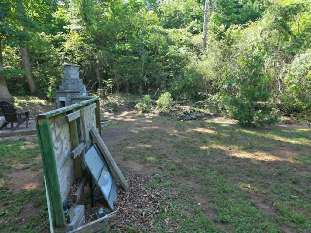 Residential backyard fully cleared after storm tree removal near outdoor fireplace – White's Tree Service Knoxville TN