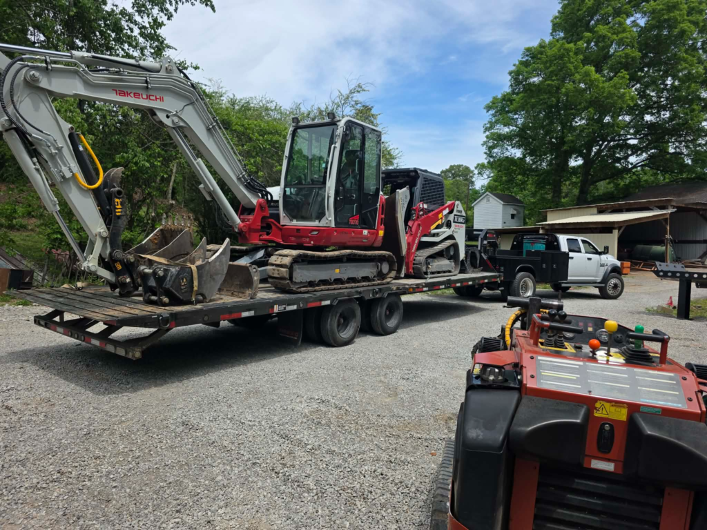 Takeuchi mini excavator and compact track loader loaded together on flatbed equipment trailer – White's Tree Service Knoxville TN