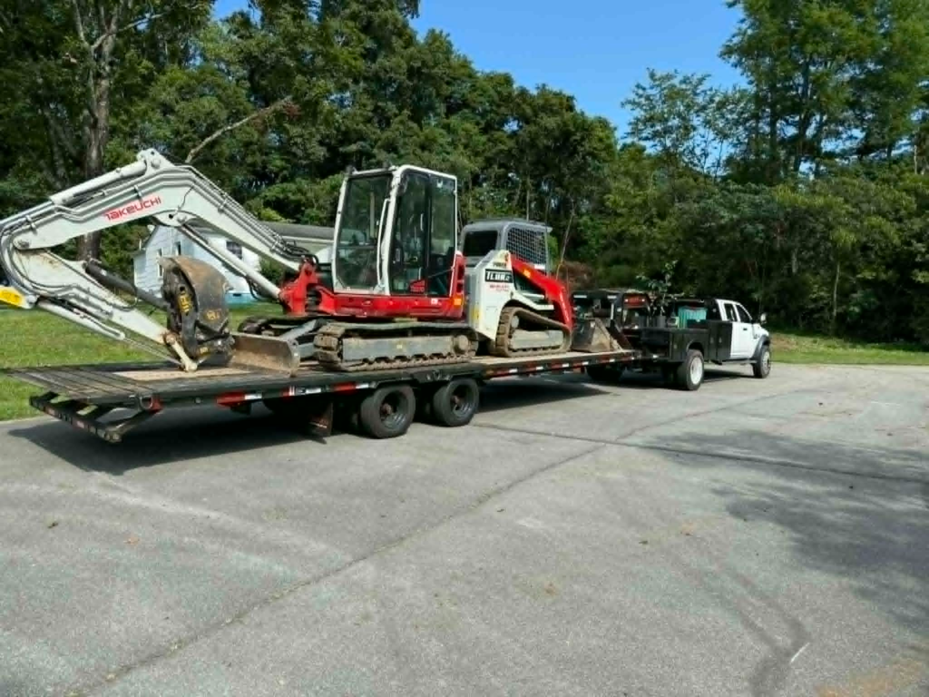 Takeuchi mini excavator and Bobcat track loader on flatbed trailer ready for job site – White's Tree Service Knoxville TN