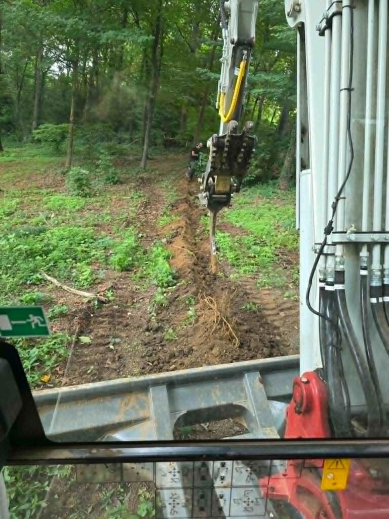 Excavator digging a trench during land clearing and site prep in Farragut, Tennessee