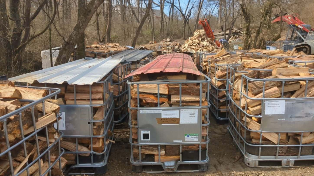 Rows of firewood totes loaded with seasoned split hardwood, staged for customer pickup at Whites Tree Services